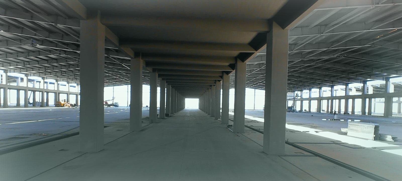 A covered concrete colonnade between the production halls at Diwan's plant