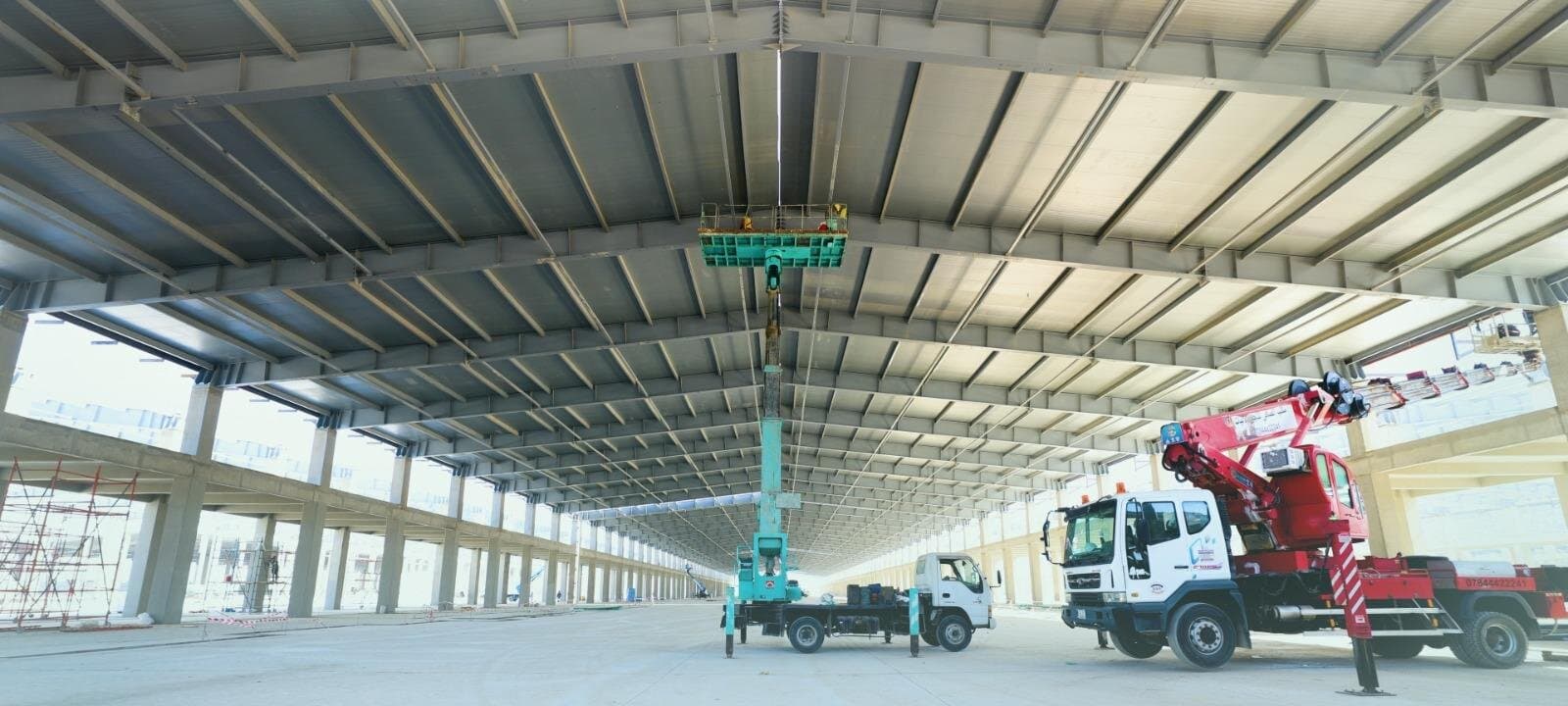 A boom lift and a crane truck at work inside a production hall at Diwan's plant