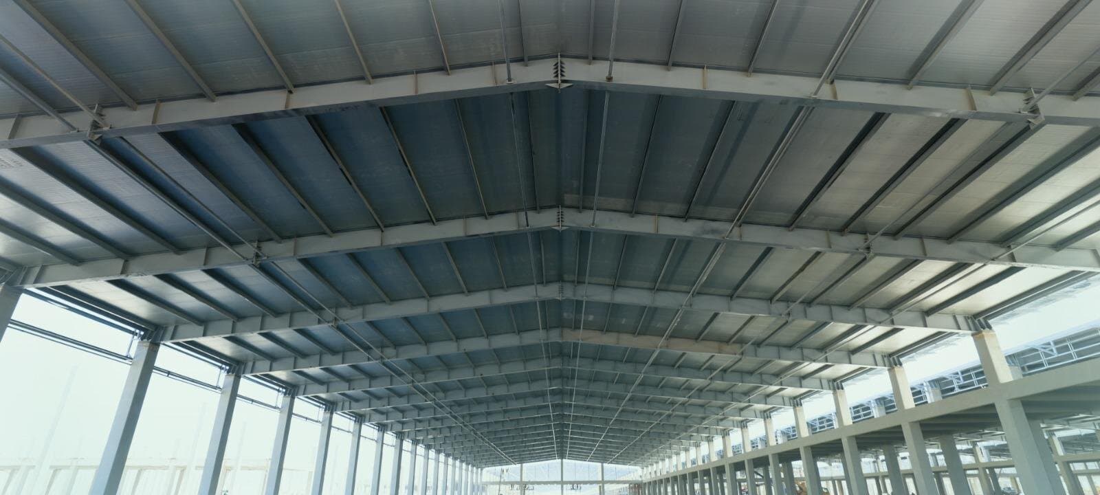 Inside a production hall at Diwan's plant, steel roof trusses running the length of the building